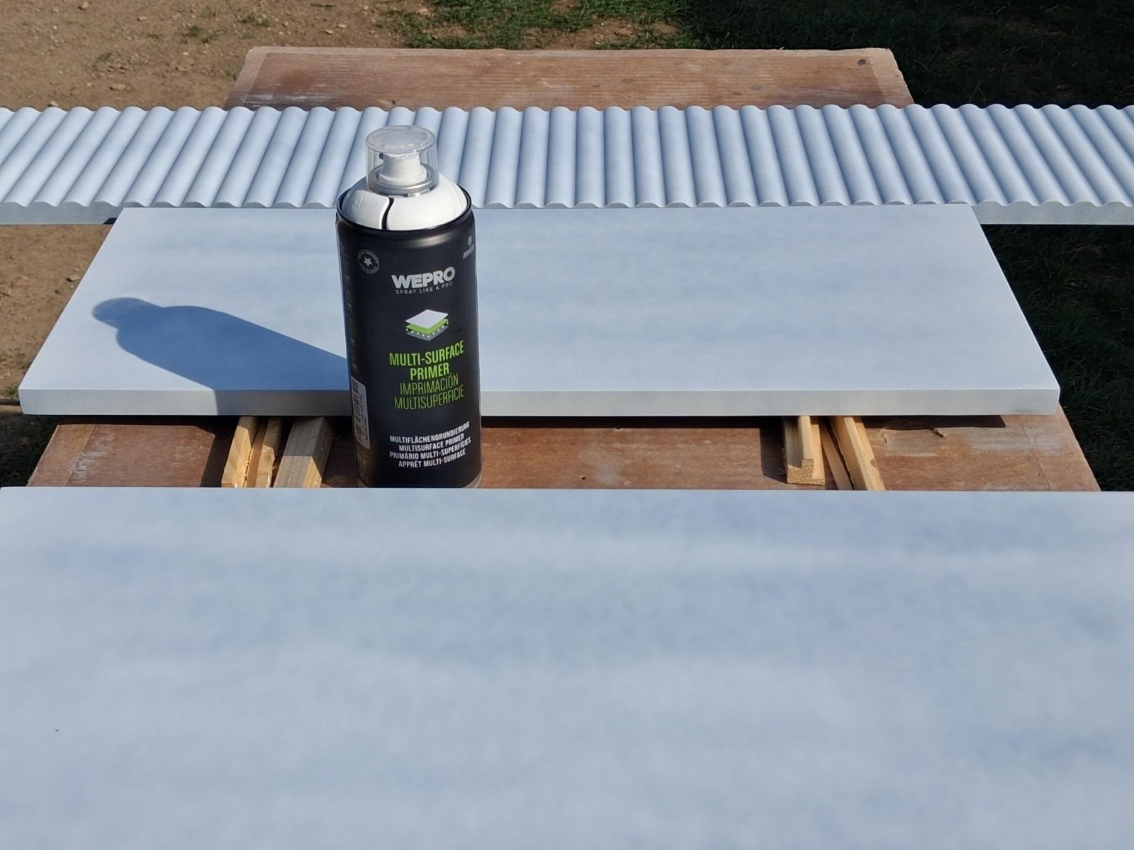 Díly stolku nastříkané světlým základem a plechovka WEPRO Multi-Surface Primer